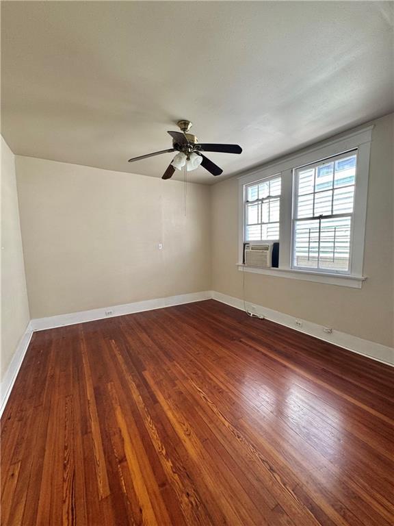 770002 Spruce St, New Orleans, LA 70118 - spare room with baseboards, dark wood-type flooring, and a ceiling fan