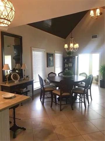 dining area featuring visible vents, high vaulted ceiling, a notable chandelier, and light tile patterned floors