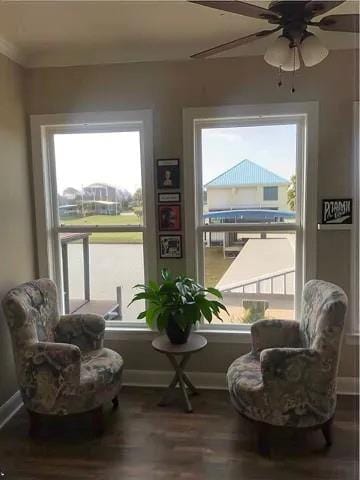 sitting room featuring a ceiling fan and baseboards