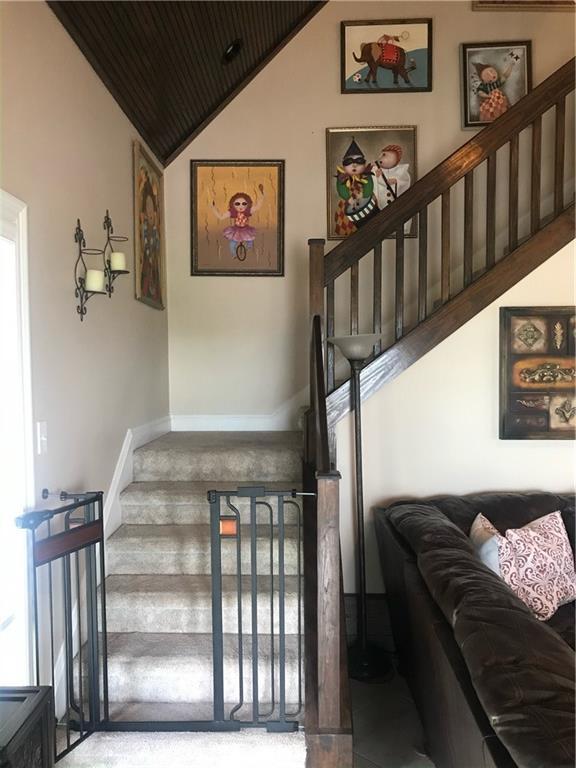 stairway with wooden ceiling, vaulted ceiling, and baseboards