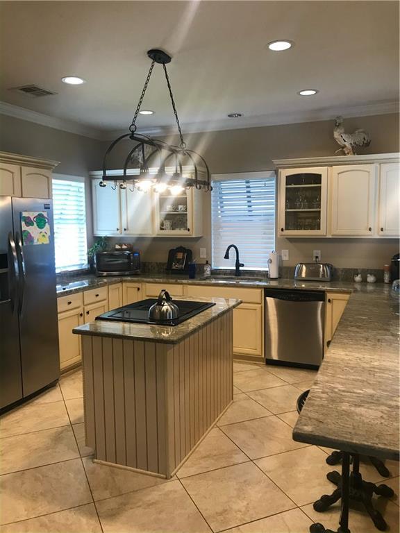 kitchen featuring visible vents, light tile patterned floors, ornamental molding, and black appliances