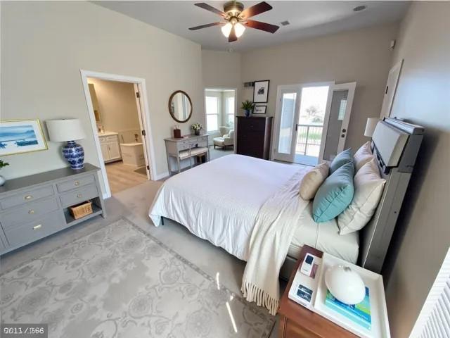 bedroom featuring ceiling fan, light carpet, and ensuite bathroom