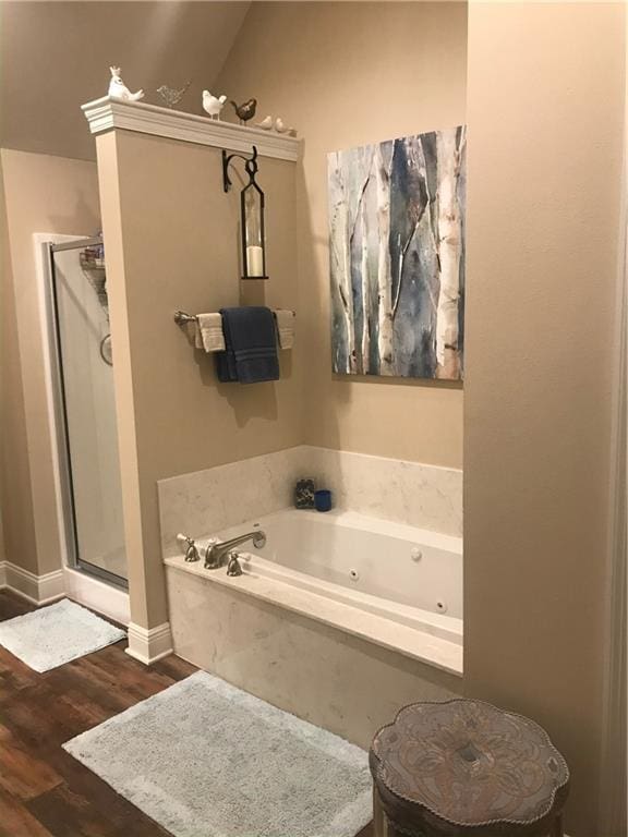 bathroom with a shower stall, baseboards, wood finished floors, and a jetted tub