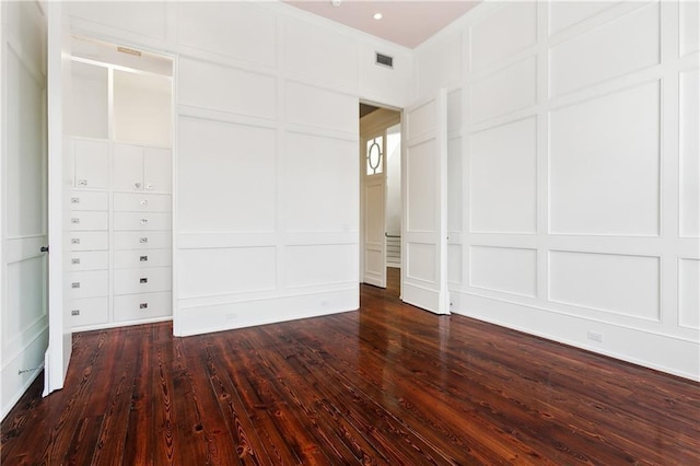 515 Ursulines Ave, New Orleans, LA 70116 - unfurnished bedroom featuring a decorative wall and dark wood-style flooring