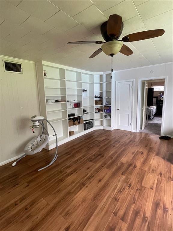 unfurnished living room featuring visible vents, ceiling fan, ornamental molding, and wood finished floors