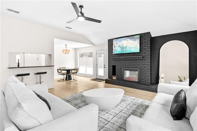 146 Bluefield Dr, Slidell, LA 70458 - living room with wood finished floors, vaulted ceiling, a ceiling fan, a chandelier, and a brick fireplace