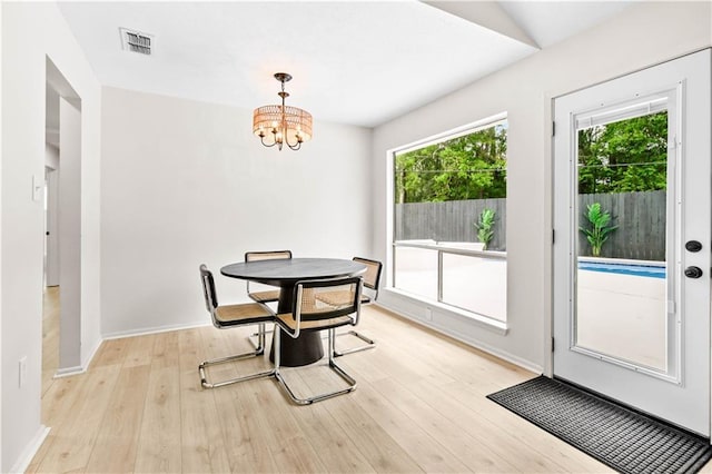 146 Bluefield Dr, Slidell, LA 70458 - dining room with a chandelier, light wood-style flooring, and baseboards