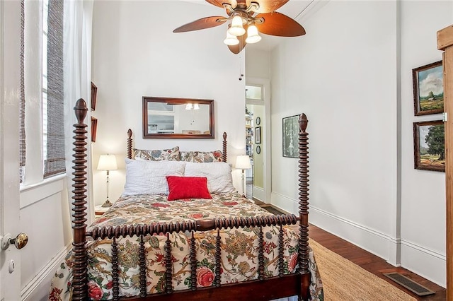 bedroom featuring a ceiling fan, wood finished floors, baseboards, and visible vents