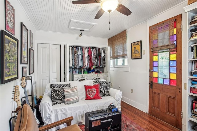 sitting room featuring baseboards, ceiling fan, wood finished floors, and separate washer and dryer