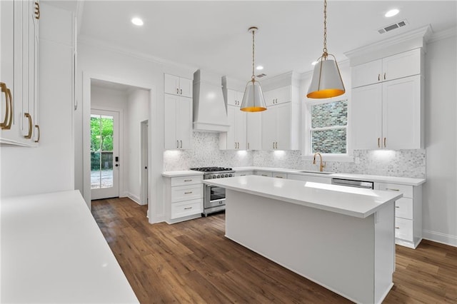 507 W 7th Ave, Covington, LA 70433 - kitchen featuring premium range hood, high end range, a sink, light countertops, and dark wood-style floors
