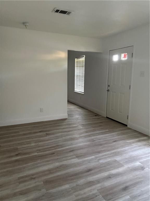 entryway featuring visible vents, baseboards, and wood finished floors