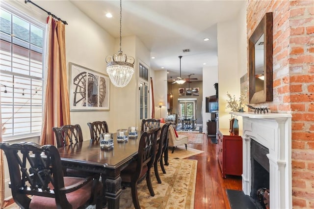 2224 N Rampart St, New Orleans, LA 70116 - dining space with wood-type flooring, ceiling fan, a fireplace, a chandelier, and recessed lighting