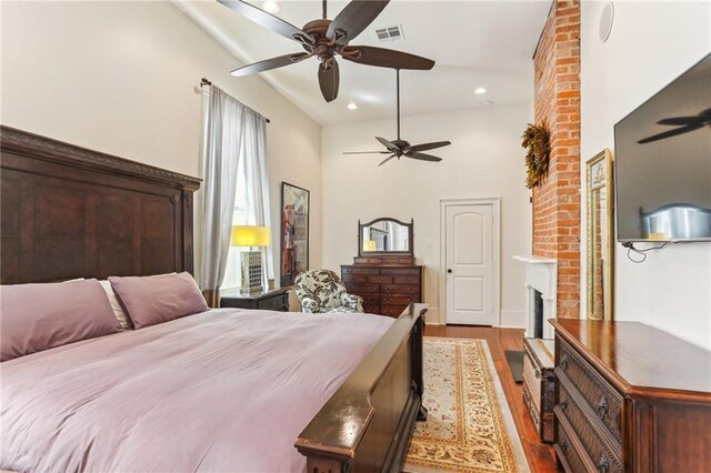 2224 N Rampart St, New Orleans, LA 70116 - bedroom with wood finished floors, a fireplace, a ceiling fan, and recessed lighting