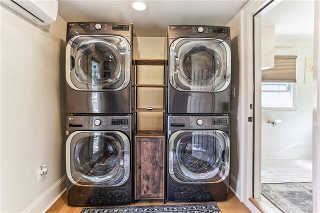 2224 N Rampart St, New Orleans, LA 70116 - laundry room featuring stacked washer and clothes dryer, a wall mounted AC, and wood finished floors