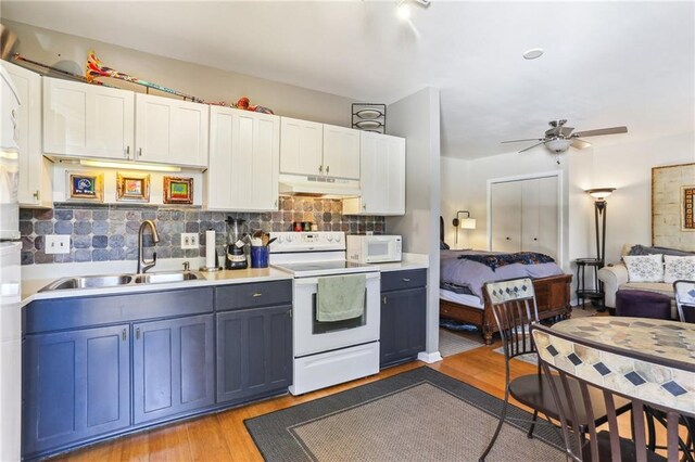 2224 N Rampart St, New Orleans, LA 70116 - kitchen with white appliances, under cabinet range hood, ceiling fan, tasteful backsplash, and light countertops