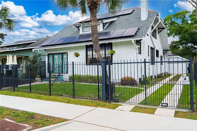 view of front of house with a front yard, stucco siding, a shingled roof, and a fenced front yard