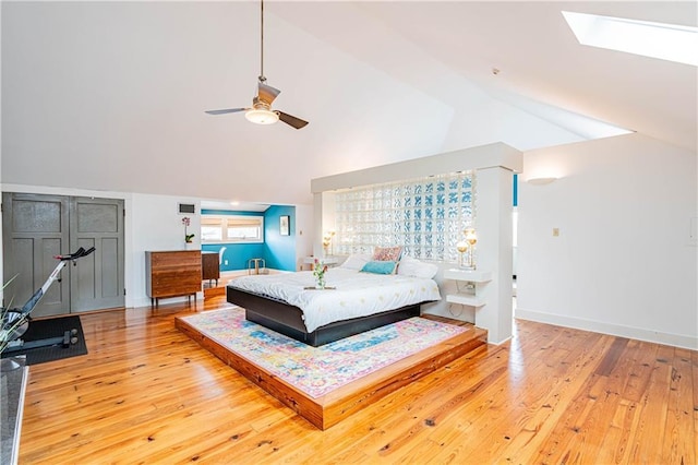 bedroom featuring wood-type flooring, a skylight, and baseboards