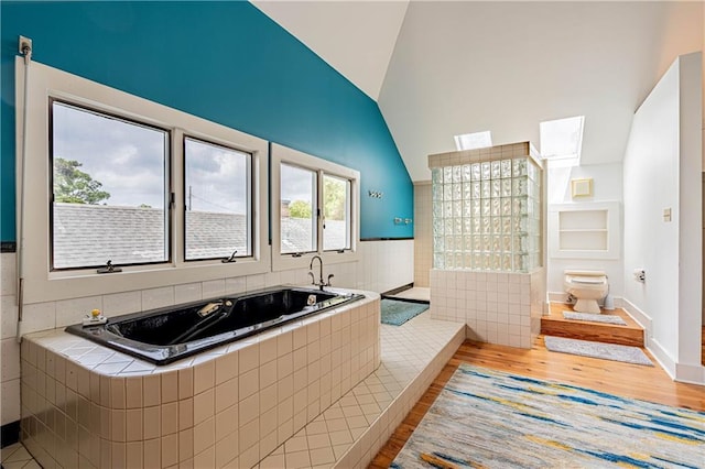 bathroom with a bath, toilet, high vaulted ceiling, and wood finished floors