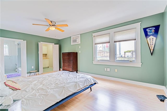 bedroom with ceiling fan, ensuite bathroom, baseboards, and wood finished floors