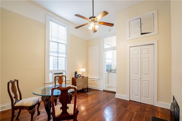 dining room featuring dark wood-style flooring, baseboards, and a ceiling fan
