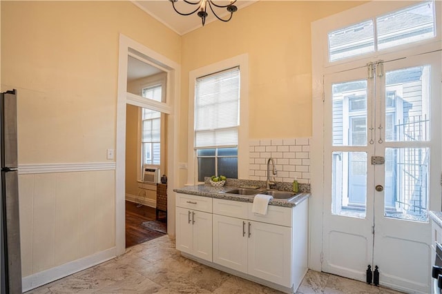kitchen featuring stone countertops, french doors, a sink, and plenty of natural light