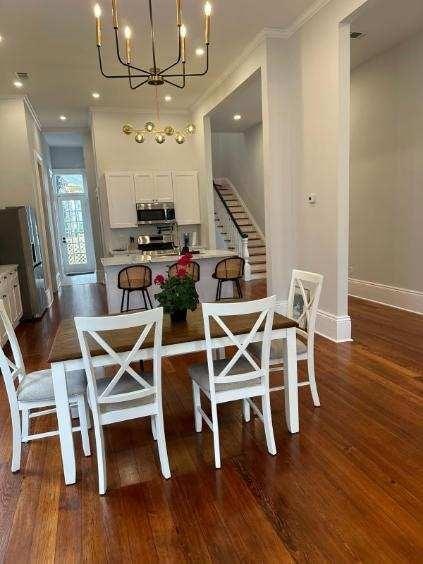 dining space with a chandelier, crown molding, and dark wood finished floors