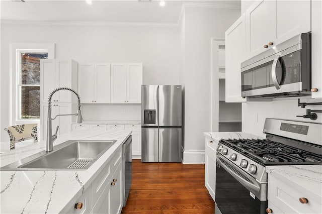 kitchen with white cabinets, a sink, ornamental molding, dark wood-style flooring, and stainless steel appliances