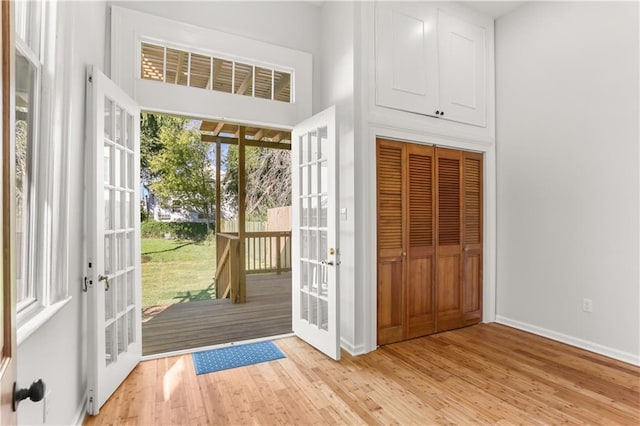 doorway to outside featuring french doors, light wood-type flooring, and baseboards