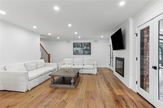102 Liberty St, Belle Chasse, LA 70037 - living area with crown molding, a fireplace, light wood-type flooring, recessed lighting, and stairs