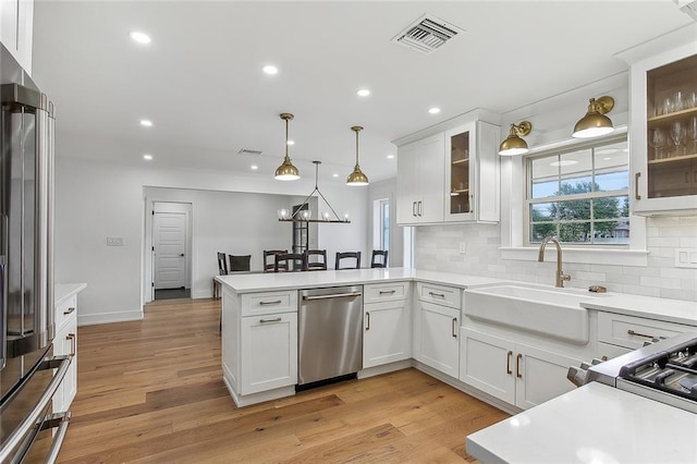 102 Liberty St, Belle Chasse, LA 70037 - kitchen featuring a peninsula, visible vents, light countertops, a sink, and stainless steel appliances