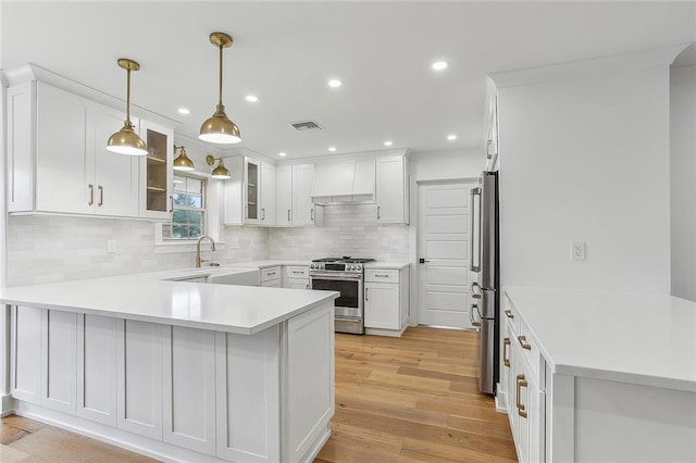 102 Liberty St, Belle Chasse, LA 70037 - kitchen featuring custom exhaust hood, visible vents, a sink, appliances with stainless steel finishes, and a peninsula