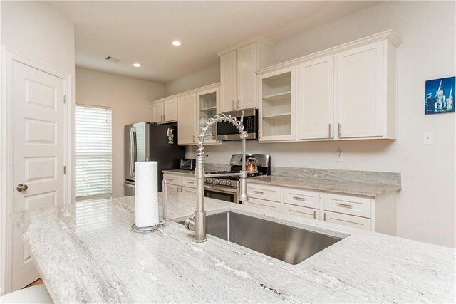 201 Belle Pointe Dr, Madisonville, LA 70447 - kitchen with stainless steel appliances, white cabinets, glass insert cabinets, light stone counters, and recessed lighting