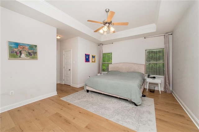 201 Belle Pointe Dr, Madisonville, LA 70447 - bedroom featuring a tray ceiling, light wood-style floors, ornamental molding, baseboards, and ceiling fan