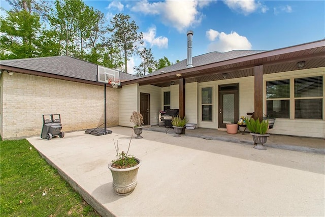 201 Belle Pointe Dr, Madisonville, LA 70447 - back of property featuring roof with shingles, brick siding, and a patio