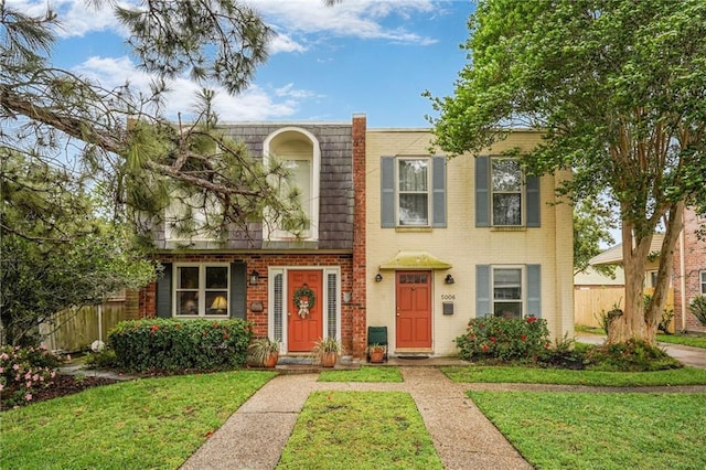 5004-0606 Newlands St, Metairie, LA 70006 - view of front of home featuring mansard roof, fence, a front lawn, and brick siding