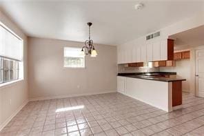 5004-0606 Newlands St, Metairie, LA 70006 - kitchen featuring a peninsula, visible vents, a chandelier, light tile patterned flooring, and dark countertops