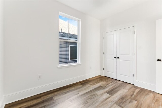 2825-27 Spain St, New Orleans, LA 70122 - unfurnished bedroom with wood finished floors, baseboards, and a closet
