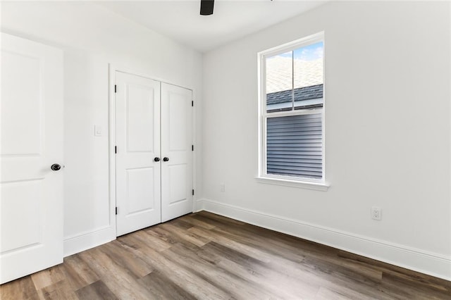2825-27 Spain St, New Orleans, LA 70122 - unfurnished bedroom featuring a closet, baseboards, ceiling fan, and wood finished floors