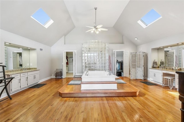 405 14th St, New Orleans, LA 70124 - bathroom featuring a skylight, wood finished floors, vanity, and a ceiling fan
