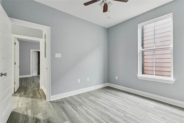unfurnished room featuring light wood-style flooring, ceiling fan, plenty of natural light, and baseboards