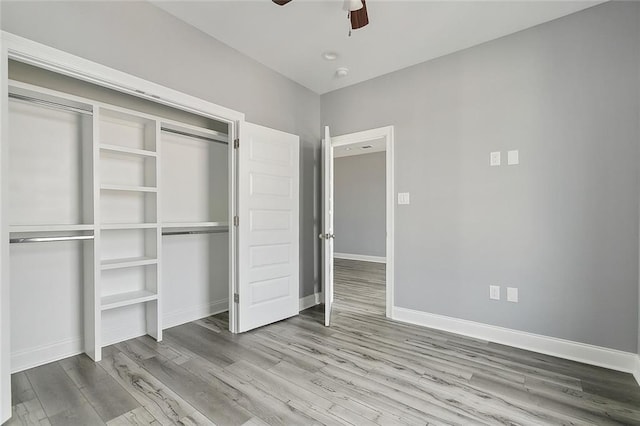 unfurnished bedroom featuring a closet, ceiling fan, baseboards, and wood finished floors