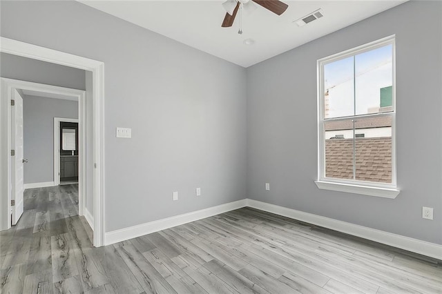 unfurnished room with wood finished floors, ceiling fan, baseboards, and visible vents
