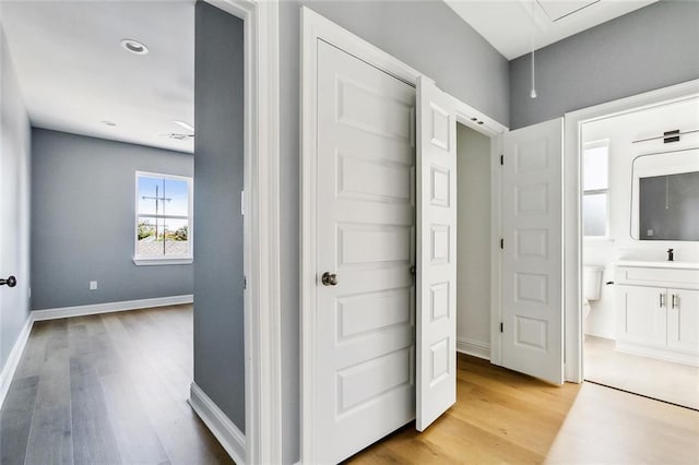 3501-03 Hamburg St, New Orleans, LA 70122 - hall featuring attic access, light wood-style floors, baseboards, and a sink