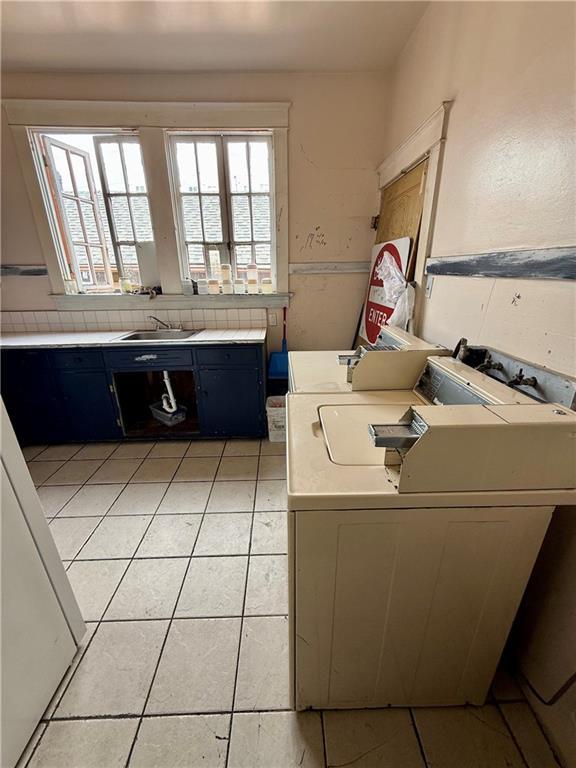 351517 Tulane Ave, New Orleans, LA 70119 - interior space with a sink, light tile patterned floors, light countertops, washing machine and clothes dryer, and blue cabinets