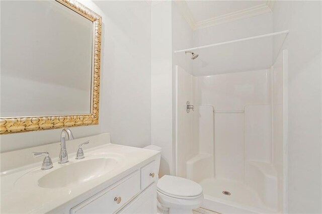 bathroom featuring ornamental molding, a shower, toilet, and vanity