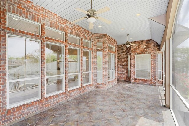unfurnished sunroom with ceiling fan, healthy amount of natural light, and lofted ceiling