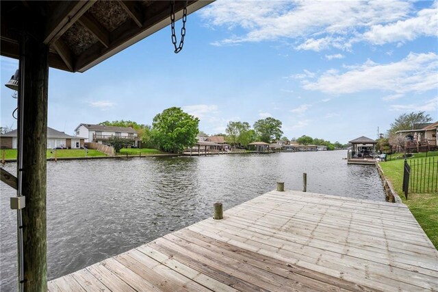 dock area with a water view, a gazebo, and a residential view