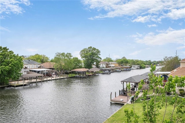 dock area featuring a water view, boat lift, and a residential view