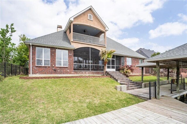 back of property with a balcony, a sunroom, roof with shingles, brick siding, and stairs