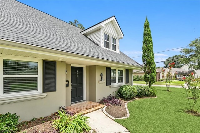 501 Gordon Ave, Harahan, LA 70123 - view of exterior entry with roof with shingles, a lawn, and stucco siding